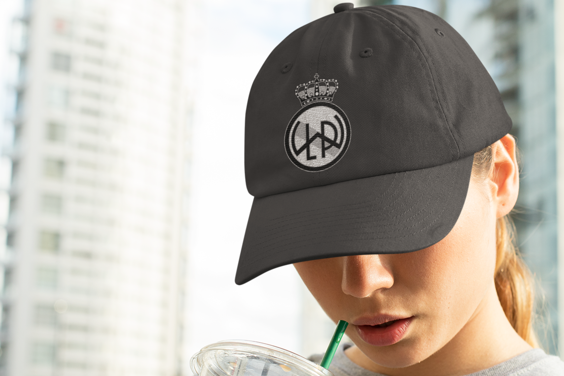 A young woman wearing a custom distressed baseball hat in near black color with LWPFC Club crest in black and gray.
